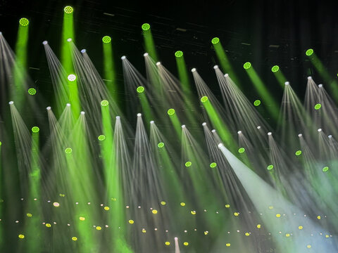 background with pattern of stage light spots creating beams and rays of green and white