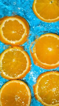 Refreshing citrus background with water moving over bright orange slices
