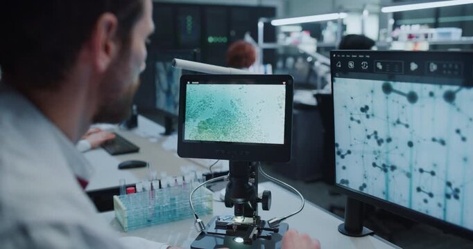 Scientist Uses Digital Microscope to Analyze Molecular Samples, Reviews Molecular Structures on Monitors in Hospital Laboratory While Female Researchers Develop Disease Treatments. Close-up Portrait