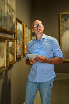 Man in the museum looks at art exhibitions gallery