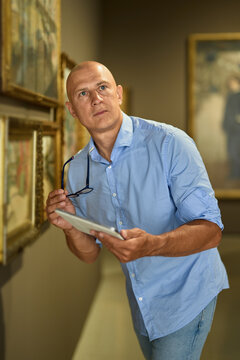 Man in the museum looks at art exhibitions gallery