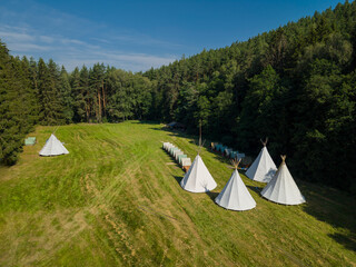 White tipis in Radejov glamping camp a summer day © Richard Semik