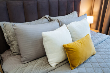 Fototapeta premium Comfortable cozy decor. Textured bedding with colorful accents. Relaxing setting featuring plush cushions and soft fabrics. Tranquil bedroom style with layered textiles and subtle hues