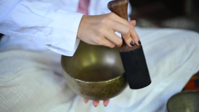 tibetan singing bowls being played on a textile with geometric patterns in a serene setting with metallic bowls and white, red, yellow, and black colors, top-down view.