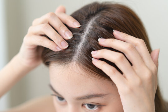 problem hair fall asian young woman, girl worry about balding, looking at scalp in mirror, hand in break into front hair loss, thin problem.