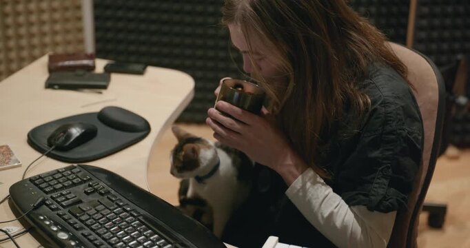 Caucasian man drink hot water in home sound recording studio while working. Single male is drinking tea in evening. 4K 10-bit