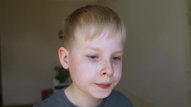 Cute 10 years old boy applying mineral sunscreen stick on his face. Caucasian child protecting freckled skin from sun damage with spf stick at home.
