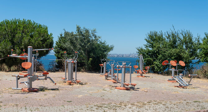 Outdoor fitness area near water with exercise equipment arranged for public use