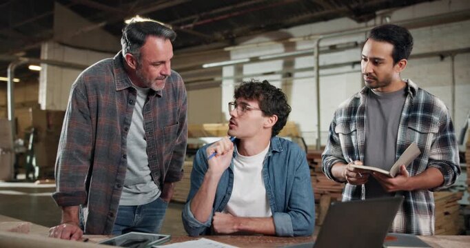 Carpenter, team and laptop in factory for planning, project management and help for apprentice. Men, tech and discussion in woodworking workshop for learning, collaboration and tips for productivity