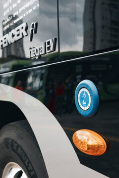 Electric bus equipped with an external accessibility request button for priority passenger boarding.