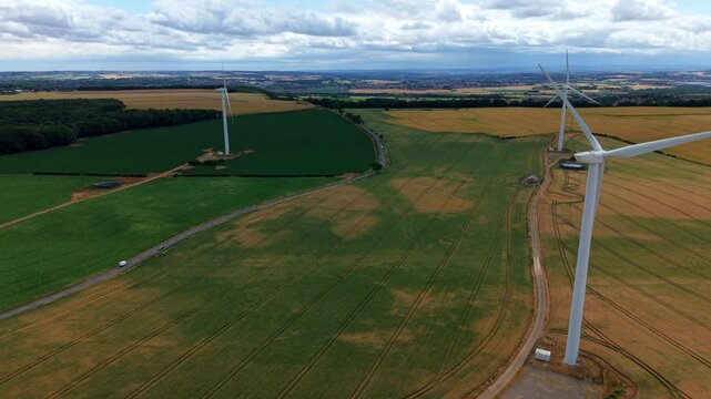 Aerial view of Marr wind farm turbines standing in the colorful patchwork fields of the rural landscape near Doncaster, South Yorkshire, UK.