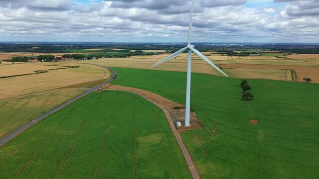 Aerial view of Marr wind farm turbines standing in the colorful patchwork fields of the rural landscape near Doncaster, South Yorkshire, UK.