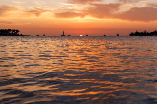 Sunset over the sea with sailing boats on the horizon