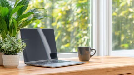 Fototapeta premium A serene workspace featuring a laptop, a coffee mug, and lush green plants by a large window