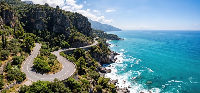 Scenic winding coastal road carved into a dramatic cliffside overlooking a vibrant blue sea and rocky shore