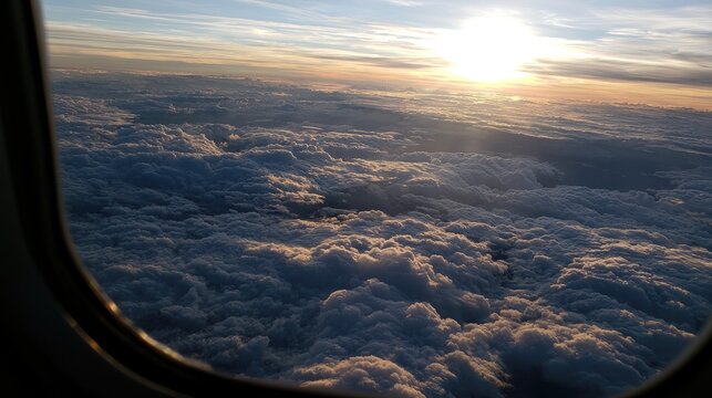 Sunrise over fluffy clouds from an airplane window, golden sunbeams piercing the sky