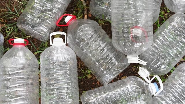 Many discarded empty plastic bottles lying on the ground, representing a major environmental problem of waste and pollution that requires urgent recycling and responsible disposal
