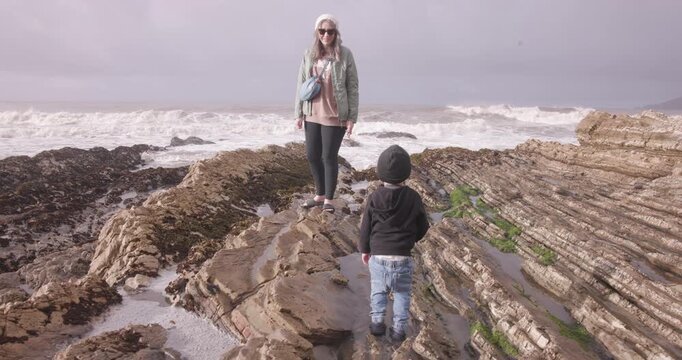 Mother Watching Toddler Explore Tide Pools at Spyglass Park, Pismo Beach, California