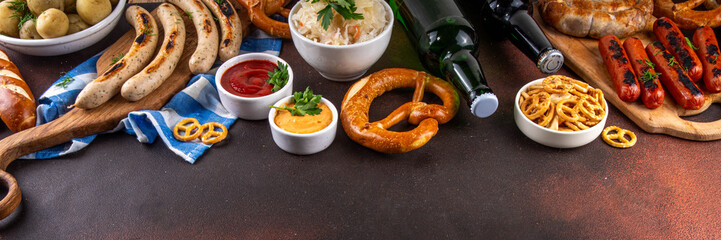 Fototapeta premium Oktoberfest picnic and barbecue food, bavarian party menu, bavarian sausages, pretzels, potato, sauerkraut, beer bottles, with picnic basket, checkered napkin tablecloth, Oktoberfest festive ribbon