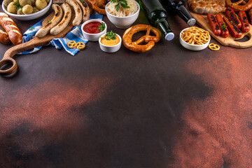 Fototapeta premium Oktoberfest picnic and barbecue food, bavarian party menu, bavarian sausages, pretzels, potato, sauerkraut, beer bottles, with picnic basket, checkered napkin tablecloth, Oktoberfest festive ribbon