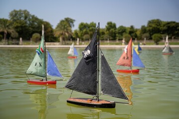 Kolorowe modele żaglówek na stawie w parku – rekreacja i hobby modelarskie © siwyk