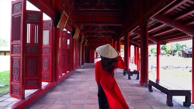 An elegant young woman in an ao dai visiting the Imperial City of Hue: a beautiful image set amidst the royal heritage of Hue, Vietnam.