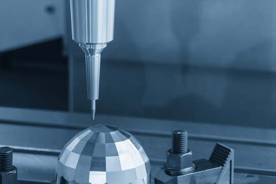 High-precision CNC milling machine performing a finishing process on metal parts with a solid ball end mill tool.