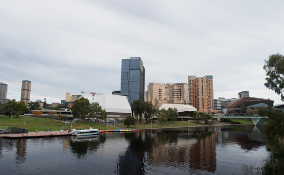 Adelaide, South Australia - April 24 2026: Adelaide city skyline with modern buildings, convention center, and a boat cruising on the scenic river torrens