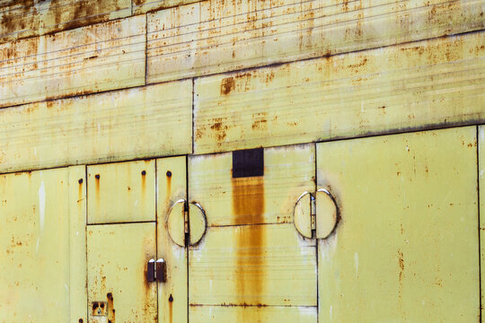 rusty yellow green painted metal barn garage doors
