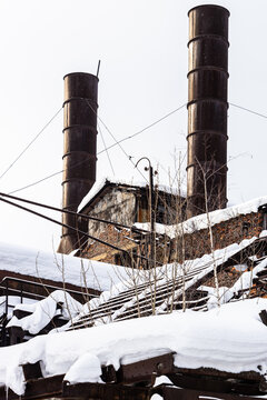 chimneys and steel frames of broken roof of plant