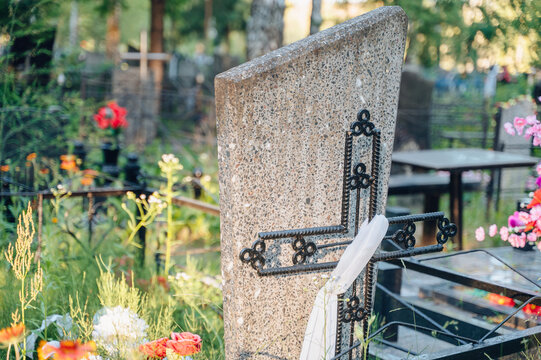 Silhouette of a black metal cross on a grave during a beautiful dramatic sunset, spiritual memory concept