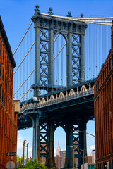 Fototapeta premium A view through a street canyon in Brooklyn (Dumbo) of a section of the world-famous Manhattan Bridge in New York (USA)