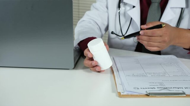 A doctor holds a bottle of pills, explains the prescription, how to use it, or the dosage to a patient, recommends quality medications, and demonstrates the concept of healthcare and treatment.

