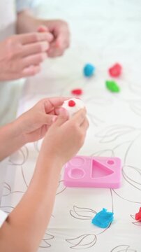 粘土遊びに集中して創造力を育む女の子・知育遊びと幼児教育など発達支援や療育、子育てのイメージ　顔無しの手元のクローズアップ縦動画