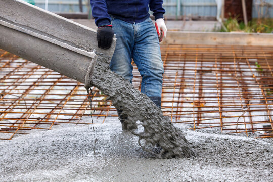 Closeup shot of concrete casting on reinforcing metal bars of floor in industrial construction site