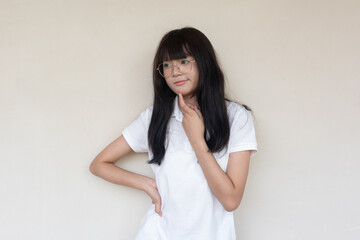 Fototapeta premium Thoughtful young Asian woman in glasses, long dark hair, hand on chin, looking sideways.