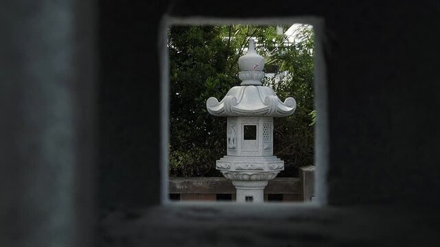 Japanese white stone lantern is a decorative garden ornament crafted from stone or marble. Full HD dolly movement, slow motion footage. Travel concept