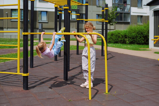Two young girls enjoying active playtime on a colorful outdoor playground