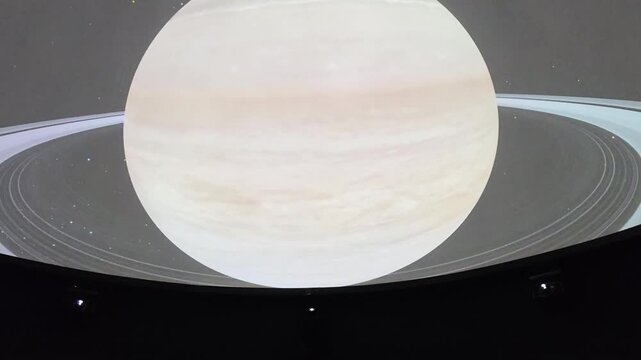 Immersive planetarium dome projection showing planet Saturn, stars constellation map and deep space universe exploration.