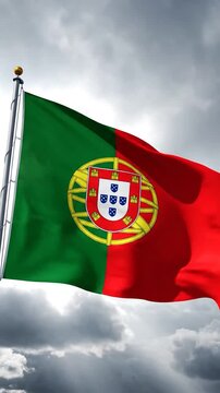 The national flag of Portugal waves against a cloudy sky