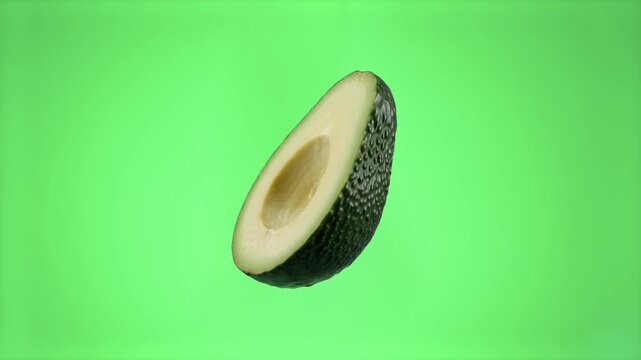 A clean halved ripe avocado without seed floating cut-side up, isolated on a solid green chroma key background. Excellent for healthy diet promos, culinary cooking guides, guacamole recipes, organic f