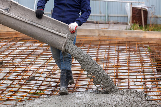 Closeup shot of concrete casting on reinforcing metal bars of floor in industrial construction site