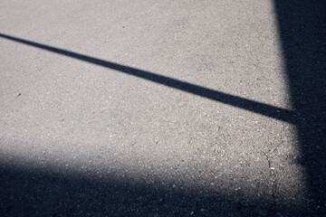 Fototapeta premium Abstraction created by the shadows of buildings on the asphalt of a city.