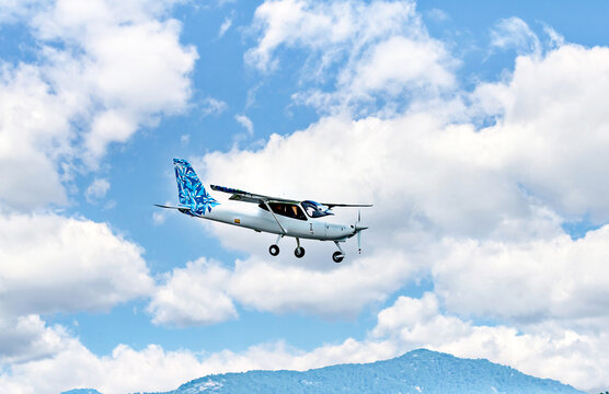 Single engine ultralight plane flying in the blue sky with white clouds