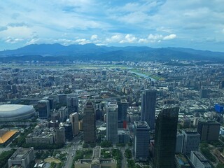 Fototapeta premium Aerial view of a dense modern cityscape with mountains in background