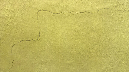 Background featuring the texture of a yellow-painted concrete wall cracked after an earthquake