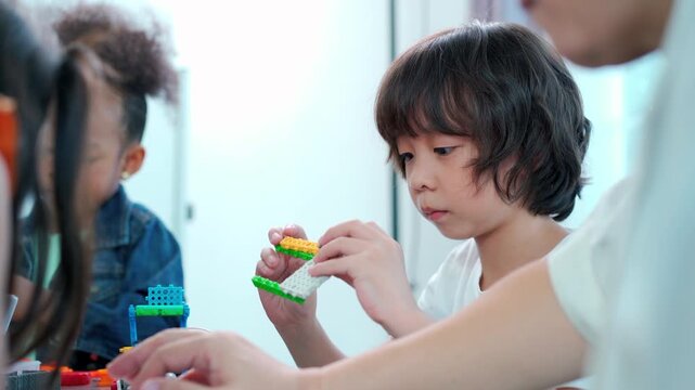 Teacher guiding multiracial children in robotics STEM class