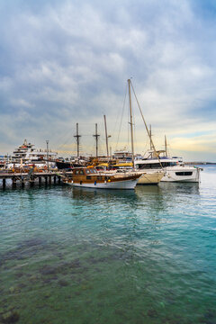 Picturesque harbor in Latchi featuring anchored yachts, sailing boats surrounded by turquoise sea. Mediterranean destination, tourism, relaxation and waterfront lifestyle concept.