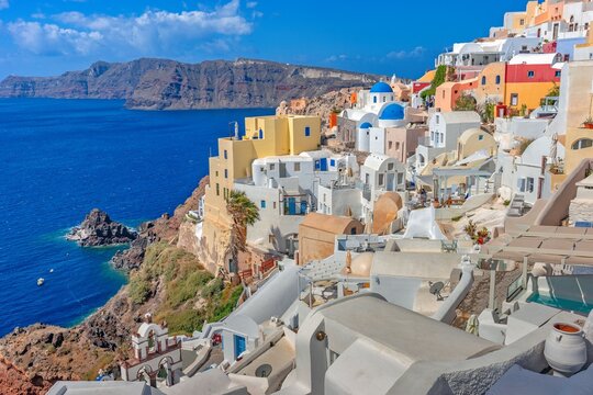 Colorful houses on a cliffside overlooking the ocean in Santorini