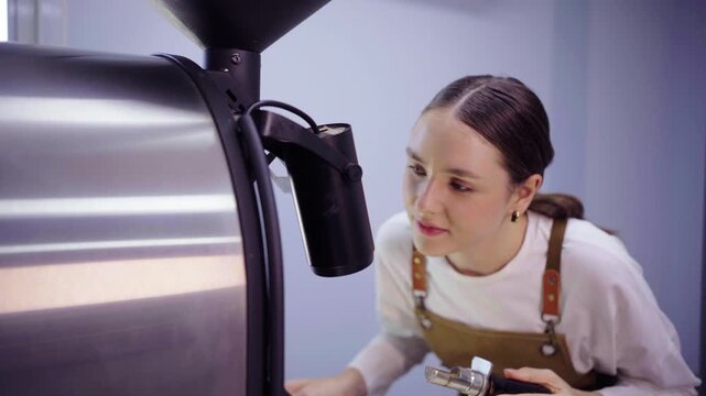 Female roaster inspecting coffee roasting machine before use